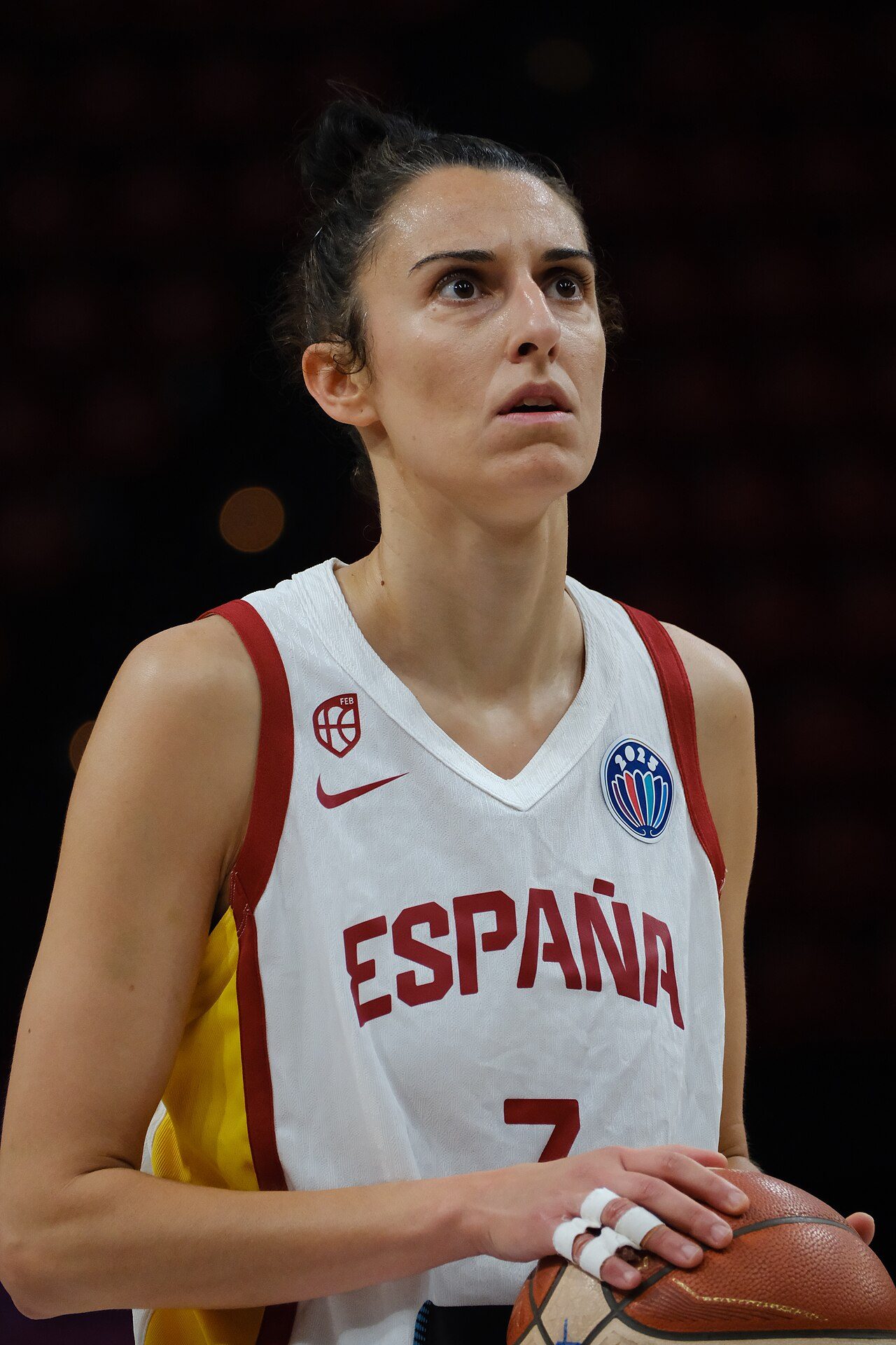 Jugadora de baloncesto con el pelo recogido en un moño alto durante un partido