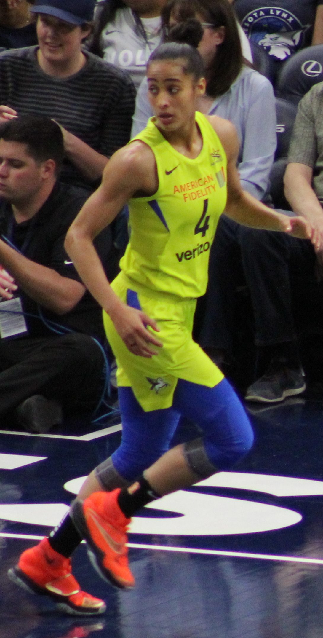 Jugadora de baloncesto con el pelo recogido en un moño alto durante un partido